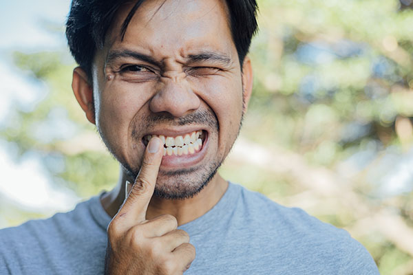 young man has strong toothache and suffering from pain ,Feel too Dr. Peter Servinis